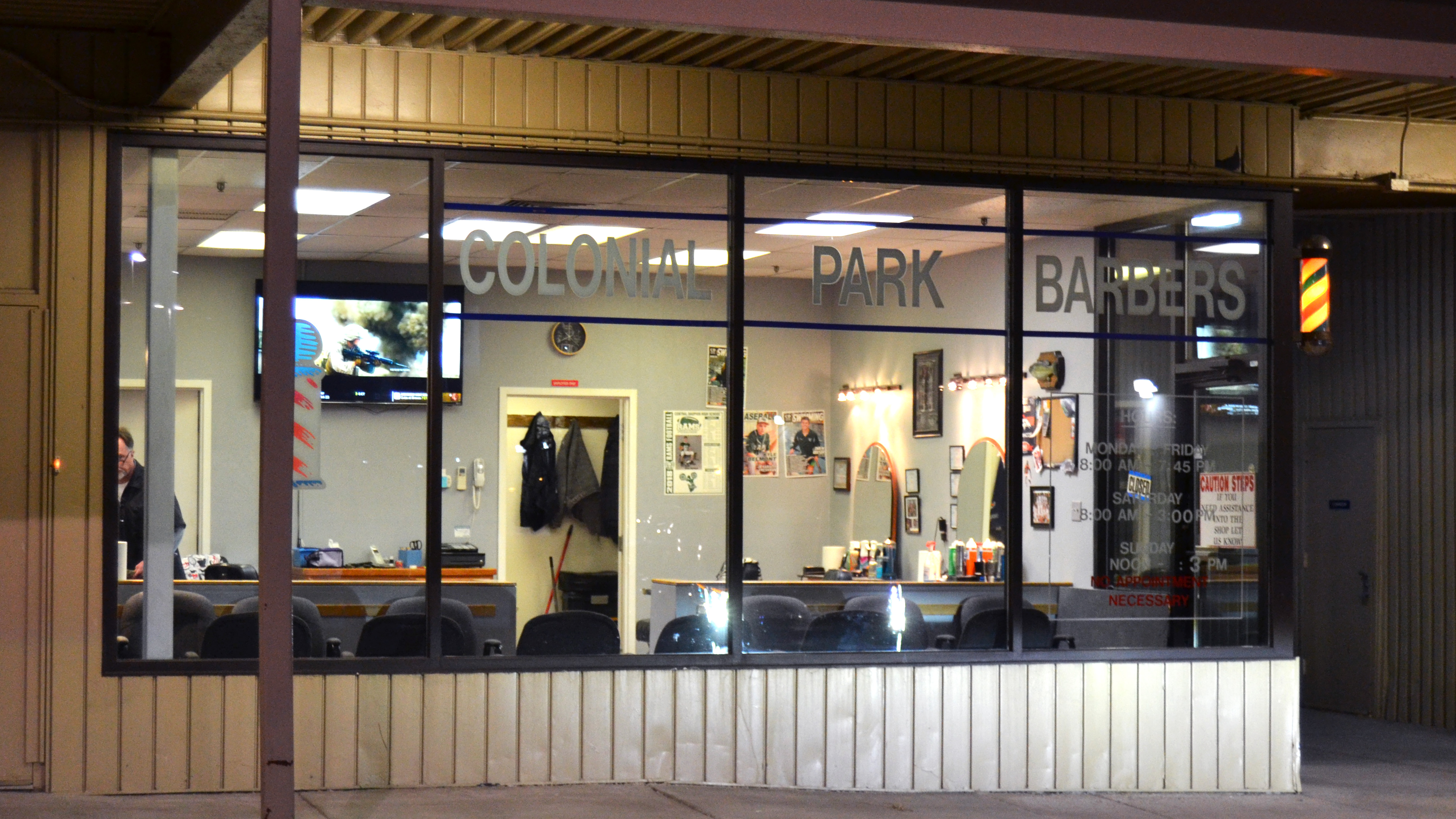 A photo of the Colonial Park Barbers storefront.